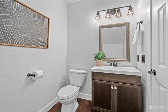 bathroom with toilet, vanity, and hardwood / wood-style flooring