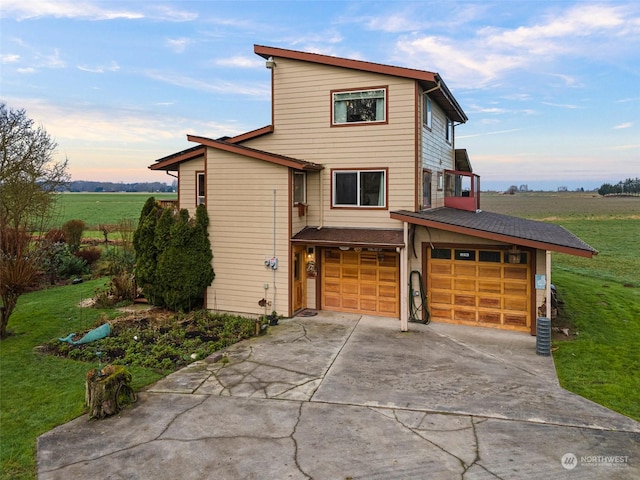 view of property featuring a yard, a rural view, and a garage