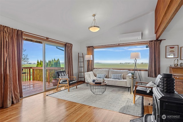 living room featuring a wall mounted AC, vaulted ceiling, and light hardwood / wood-style floors