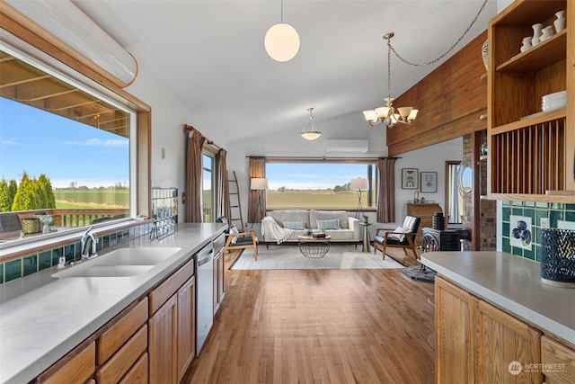 kitchen with sink, pendant lighting, dishwasher, and vaulted ceiling