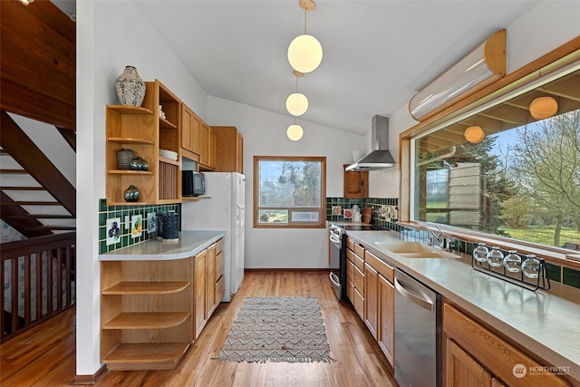 kitchen with sink, light hardwood / wood-style flooring, wall chimney range hood, pendant lighting, and appliances with stainless steel finishes