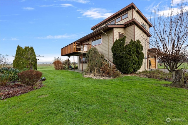 view of side of property with a yard and a wooden deck