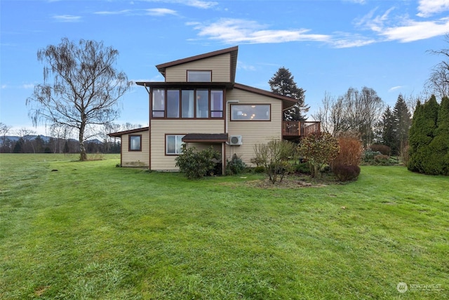 rear view of property with a deck and a yard