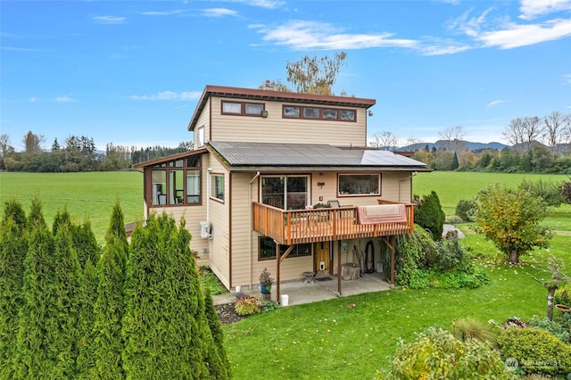 rear view of property with a yard, a deck, and a patio area