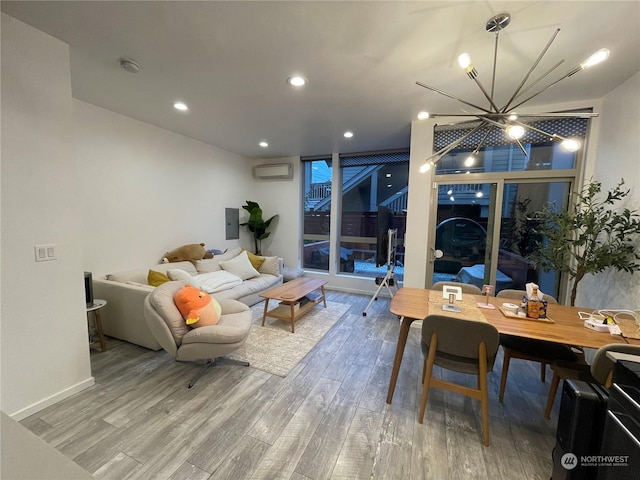 living room featuring hardwood / wood-style flooring, a wall unit AC, and a chandelier