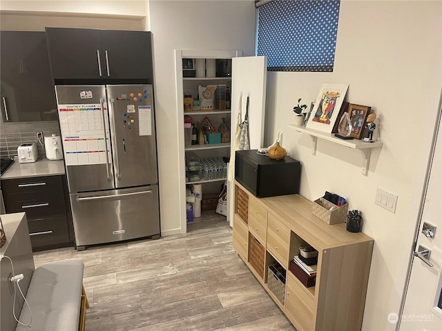 kitchen with high end fridge, light hardwood / wood-style floors, and backsplash