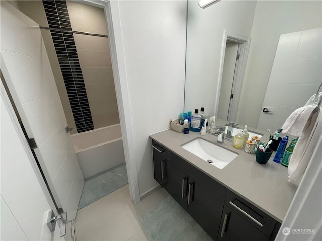 bathroom with tile patterned flooring, tiled shower / bath combo, and vanity