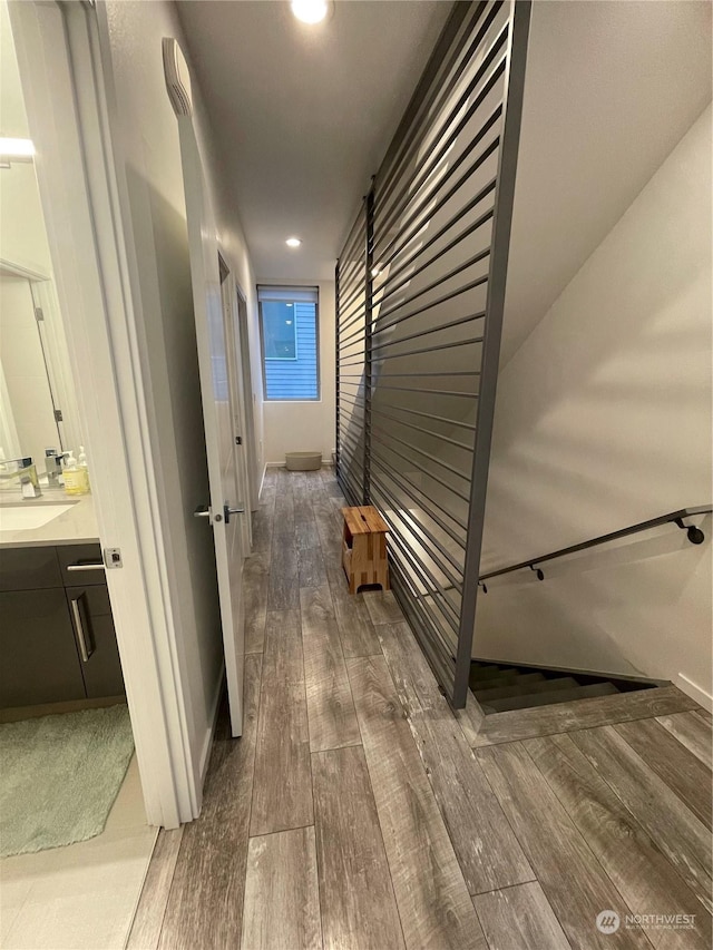 corridor with dark wood-type flooring and sink