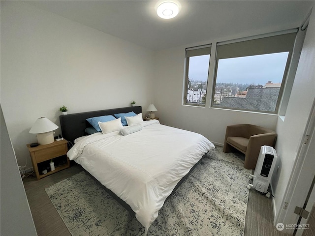 bedroom featuring wood-type flooring and heating unit