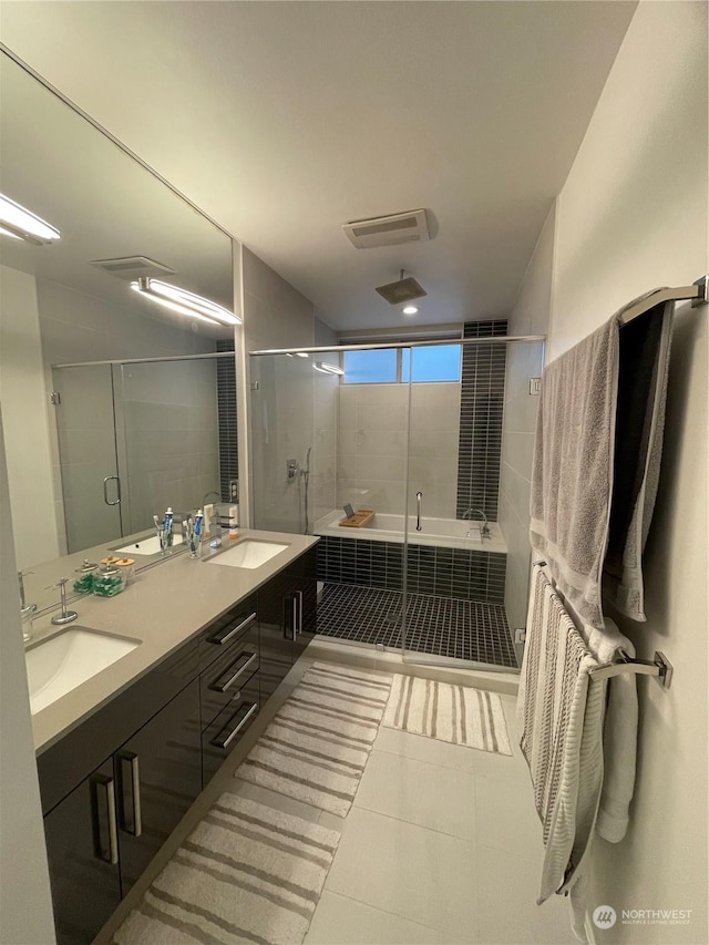 bathroom with tile patterned flooring, independent shower and bath, and vanity