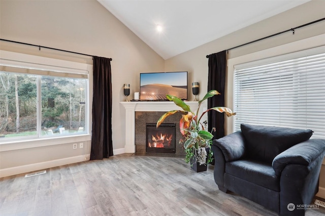 sitting room with hardwood / wood-style flooring and vaulted ceiling