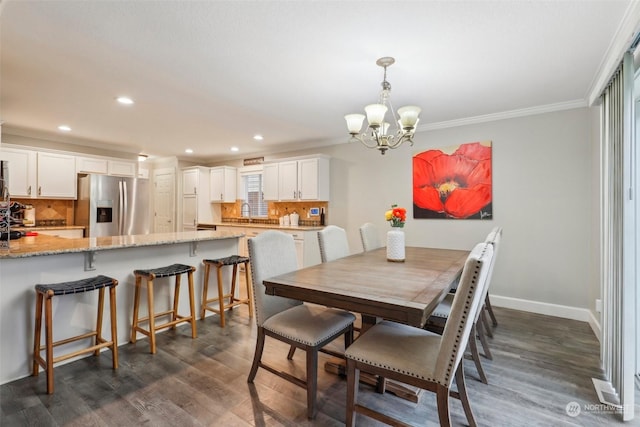 dining space with crown molding, sink, a notable chandelier, and dark hardwood / wood-style flooring