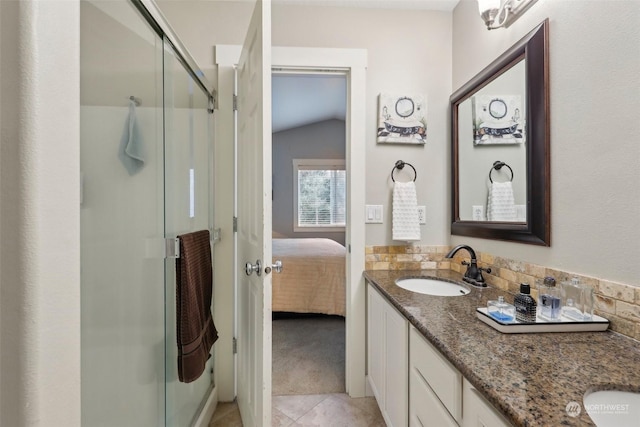 bathroom with tasteful backsplash, lofted ceiling, vanity, walk in shower, and tile patterned floors