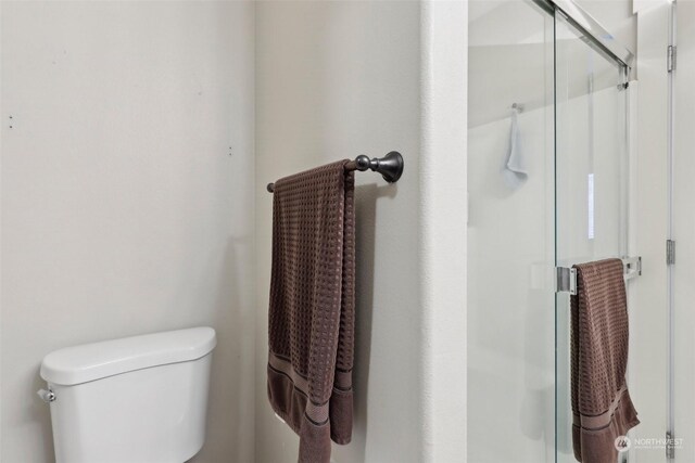 bathroom with an enclosed shower and toilet