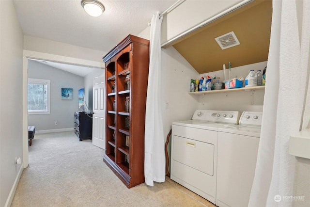 laundry area featuring light colored carpet and washer and clothes dryer