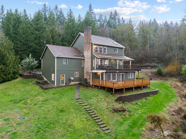 rear view of house with a deck and a lawn