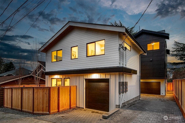 back house at dusk with a garage