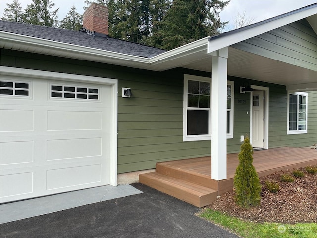 property entrance with a garage and covered porch