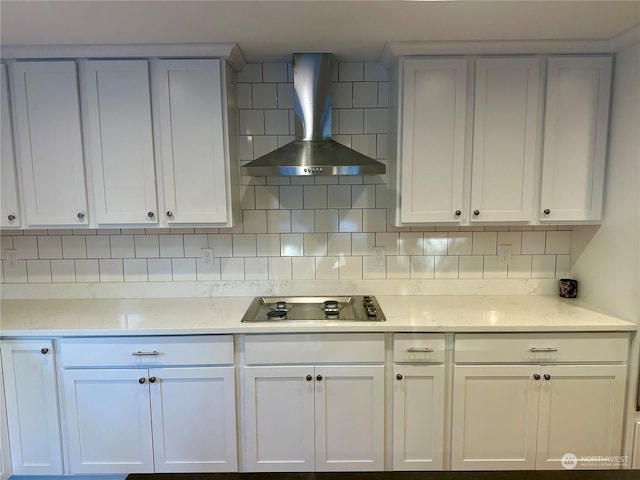 kitchen featuring white cabinetry, light stone counters, wall chimney exhaust hood, backsplash, and black electric cooktop