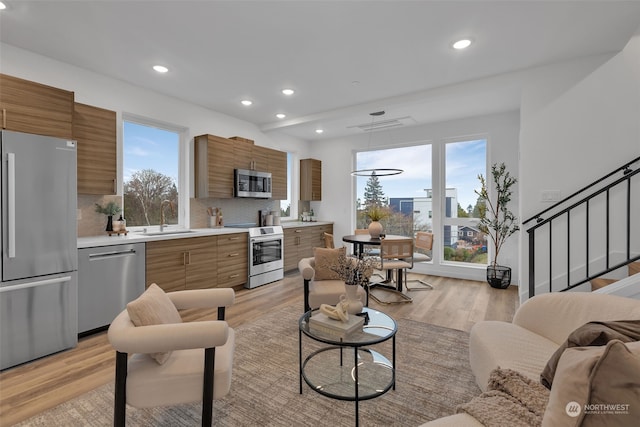 living room with sink and light hardwood / wood-style flooring