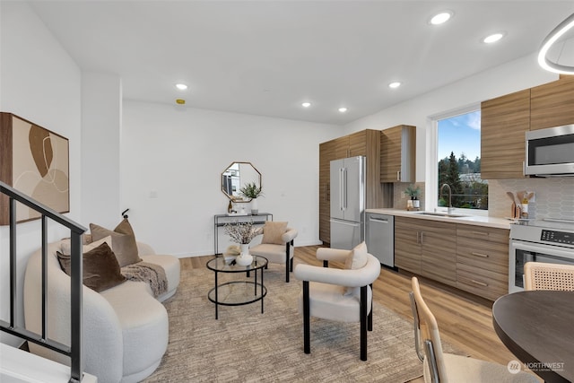 living room with sink and light hardwood / wood-style floors