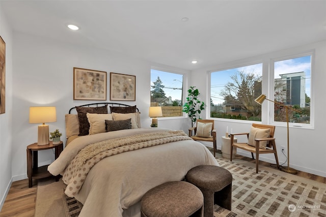 bedroom with light wood-type flooring and multiple windows