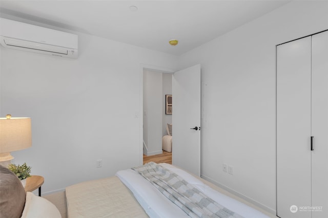 bedroom with a wall mounted air conditioner and a closet