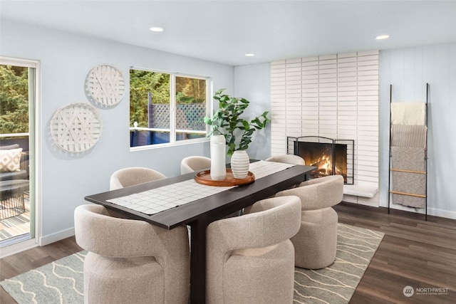 dining space featuring dark hardwood / wood-style flooring and a fireplace