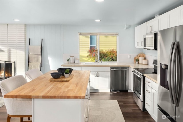 kitchen featuring a breakfast bar, sink, a kitchen island, stainless steel appliances, and white cabinets