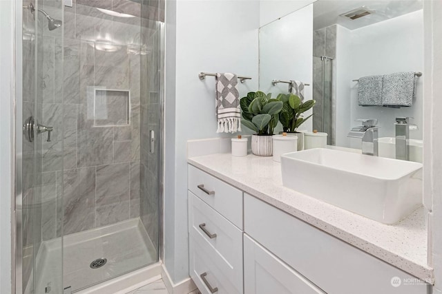 bathroom with a shower with door and vanity