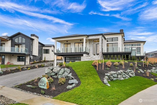 view of front of property featuring a front yard and a balcony