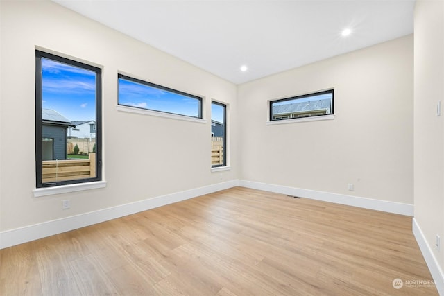 spare room with recessed lighting, light wood-type flooring, and baseboards