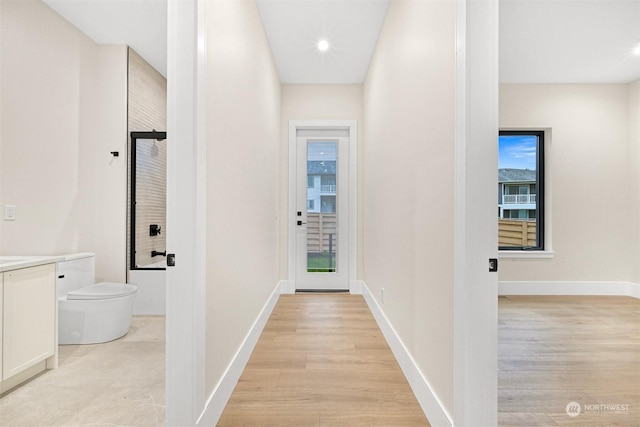 hall with recessed lighting, baseboards, and light wood-style floors