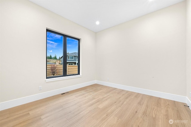 spare room featuring light wood finished floors, visible vents, recessed lighting, and baseboards