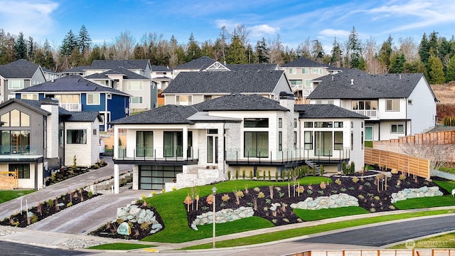 view of front of home featuring a garage, a residential view, driveway, and a shingled roof