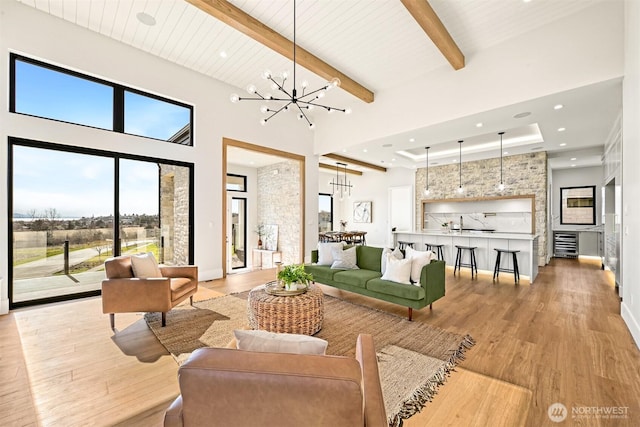 living room featuring light wood finished floors, a high ceiling, and an inviting chandelier