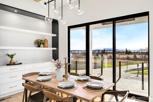 dining space featuring visible vents and light wood-style flooring