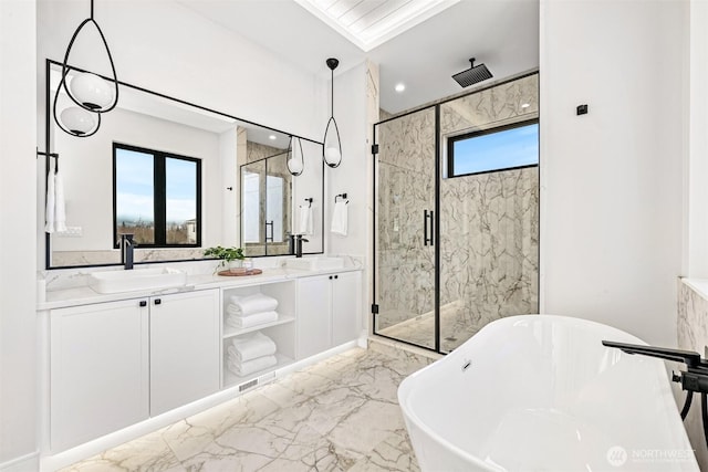 bathroom featuring a marble finish shower, double vanity, a freestanding tub, a sink, and marble finish floor