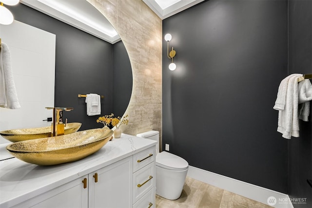 bathroom featuring vanity, toilet, wood finished floors, and baseboards