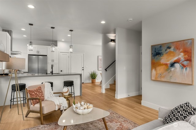 living room with light hardwood / wood-style floors and sink