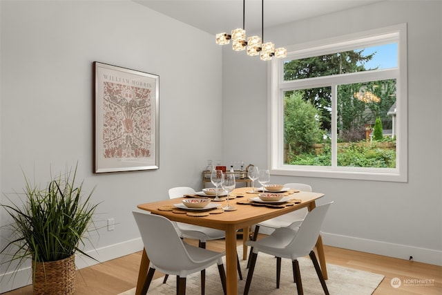 dining room with light hardwood / wood-style floors and a notable chandelier