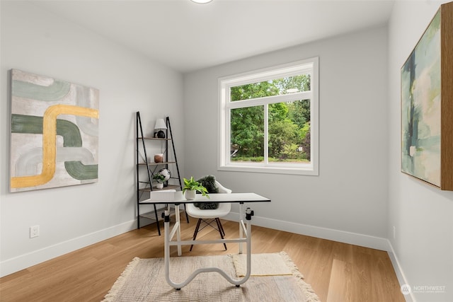 home office with light hardwood / wood-style flooring