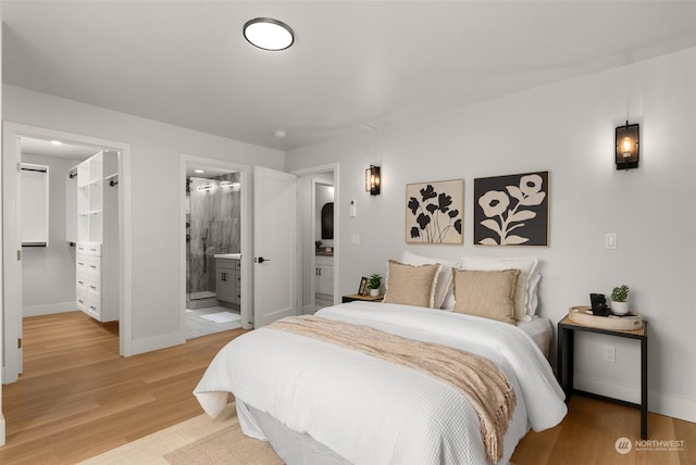 bedroom featuring ensuite bath and hardwood / wood-style floors