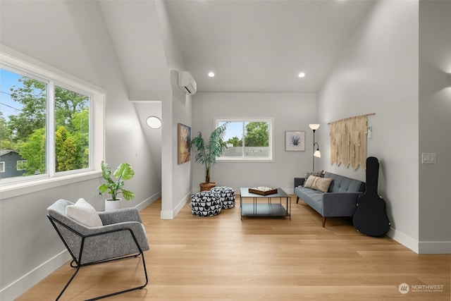 living area with light hardwood / wood-style floors and a wall unit AC