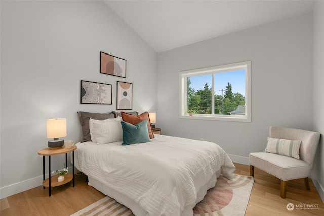 bedroom with vaulted ceiling and light hardwood / wood-style floors