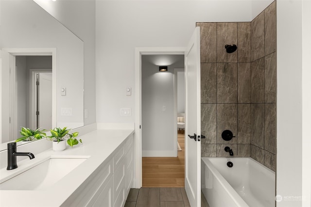 bathroom featuring vanity and tiled shower / bath