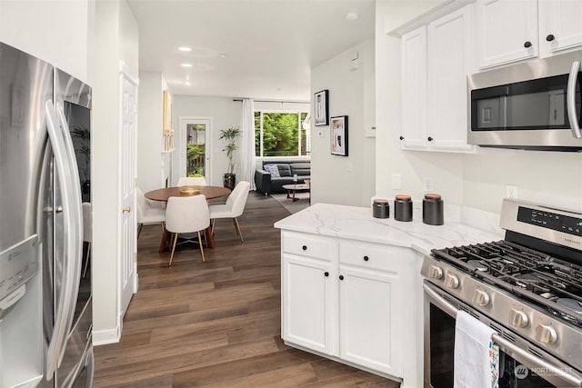 kitchen with white cabinets, stainless steel appliances, dark hardwood / wood-style flooring, and light stone countertops