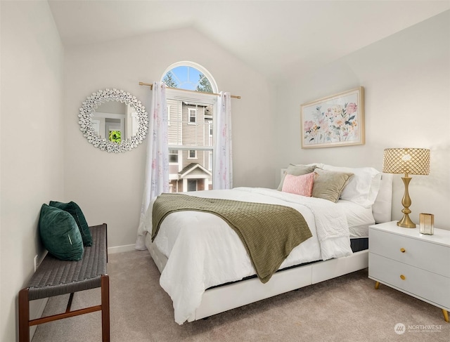 bedroom with light colored carpet and lofted ceiling