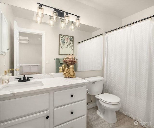 bathroom with toilet, hardwood / wood-style flooring, a shower with curtain, and vanity