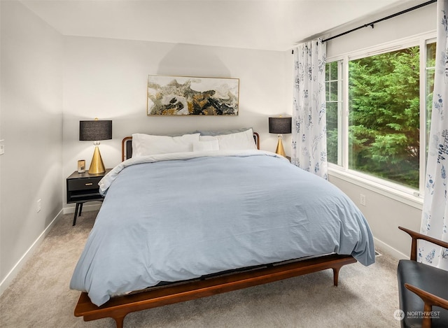 bedroom with light colored carpet and multiple windows